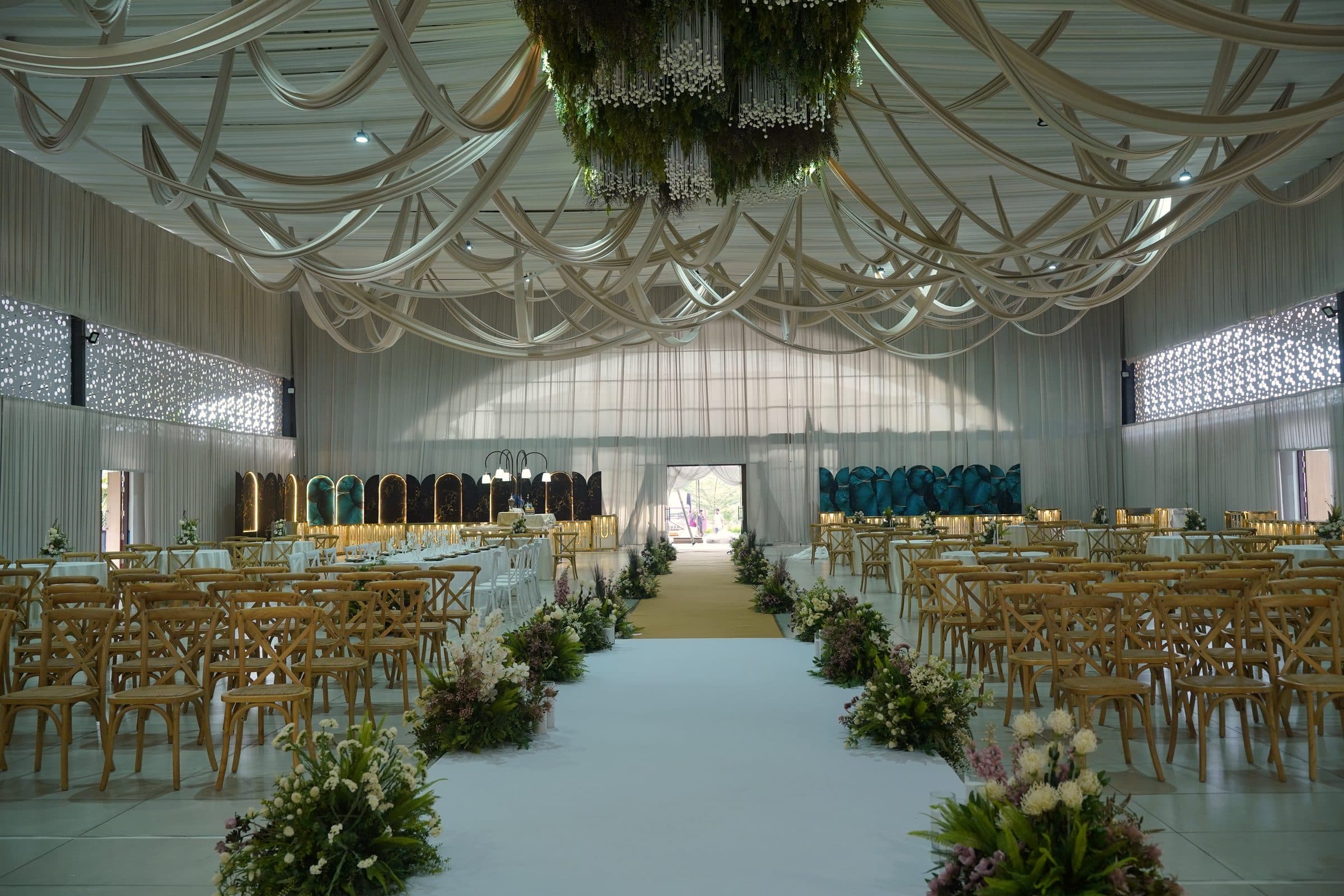 The full length of the hall down its centre aisle, doors open at the far end