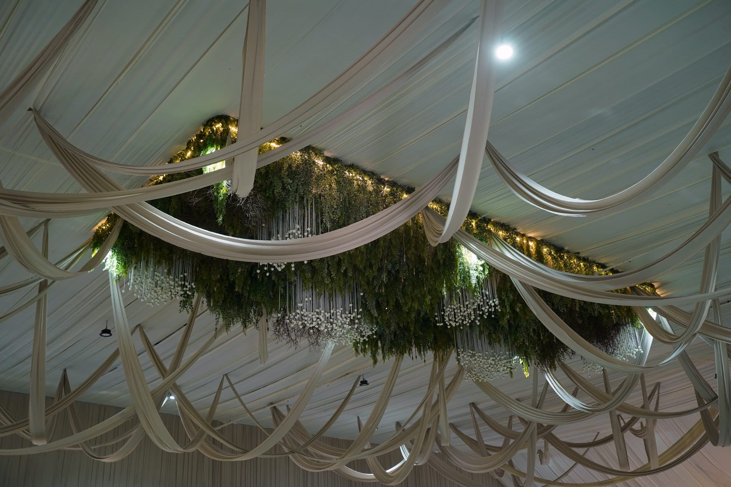 Detail of the ceiling drapery and the greenery suspended through it